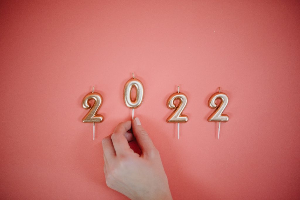 Woman holding candles that read 2022 for New Years
